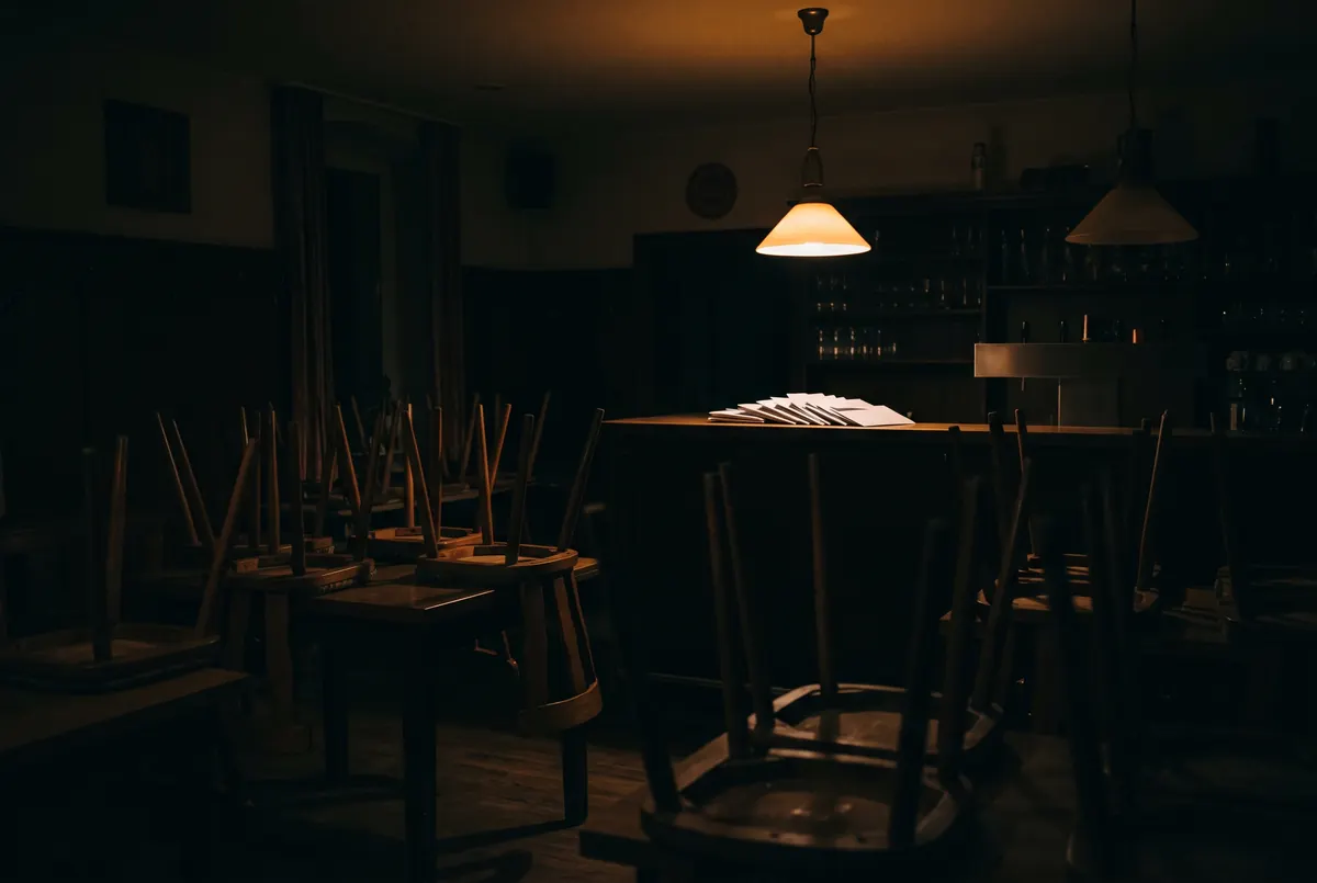 Geschlossenes Restaurant bei Nacht: Stühle auf den Tischen, ein Stapel Briefe auf dem Tresen